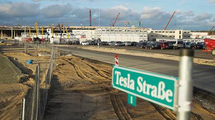 Grünheide: Blick auf das Straßenschild „Tesla Straße 1“ vor der Baustelle der Tesla-Fabrik. 