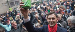 Martin Hikel (SPD), Bezirksbürgermeister von Berlin-Neukölln, hält beim ersten Hilfe-Flashmob «Kaffee gegen Kälte» zusammen mit zahlreichen anderen Spendern ein Paket Kaffee in die Höhe. 