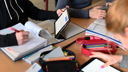 Realschüler einer zehnten Klasse arbeiten in einer Unterrichtsstunde mit Tablets.