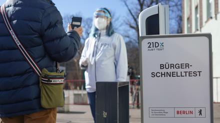 Eine Mitarbeiterin der Betreiber-Firma 21Dx GmbH und ein Bürger stehen vor einem Corona-Schnelltestzentrum in der Lehrter Straße hinter einem Schild mit der Aufschrift «Bürger-Schnelltest». Seit dem heutigen Tag ermöglicht die Bundesregierung allen Bundesbürgern kostenfreie Corona-Tests. +++ dpa-Bildfunk +++