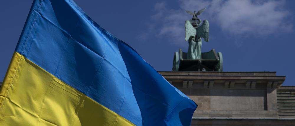 Die Fahne der Ukraine weht bei einer Protestaktion gegen den russischen Krieg in der Ukraine am Brandenburger Tor. 