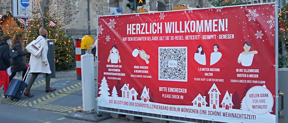 Auf dem Weihnachtsmarkt am Breitscheidplatz weisen Plakate auf die 3G-Regel hin. Doch kontrolliert wird sie nicht. 