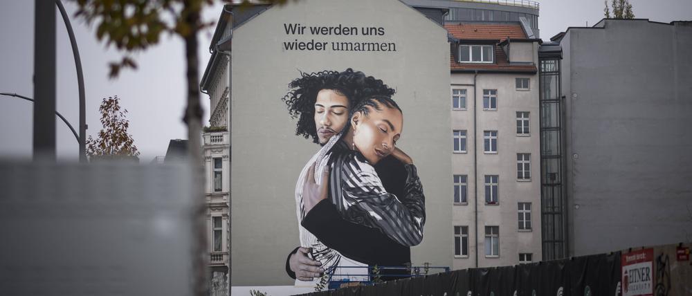 Ein bisschen Hoffnung. Werbebild mit zwei sich umarmenden Menschen in Berlin Mitte. 