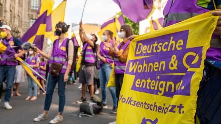 Unterstützer der Initiative „Deutsche Wohnen & Co. enteignen“ in uniformen Farben und mit Fahnen.