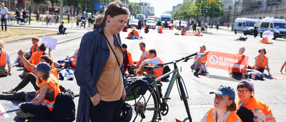 Clara Herrmann, District Mayor of Friedrichshain-Kreuzberg speaks with "Letzte Generation" (Last Generation) activists, as they block a road, to protest under the slogan "Let's stop the fossil madness!" for an end to fossil fuels and against oil drilling in the North Sea, in Berlin, Germany June 23, 2022. REUTERS/Christian Mang