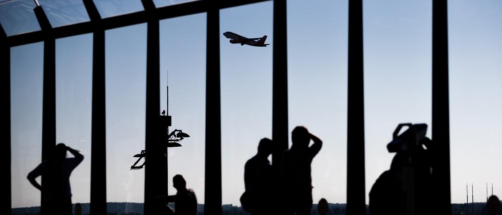 Besucher schauen sich am Hauptstadtflughafen Berlin Brandenburg «Willy Brandt» (BER) von der Besucherterrasse des Terminal 1 den Start eines Flugzeugs an.