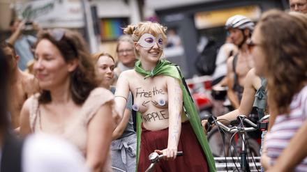 Eine Frau fordert bei einer Fahrraddemo mit dem Spruch „Free the nipple“ Gleichberechtigung. 