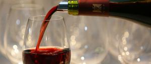 Rotwein wird in ein Weinglas gefüllt.
