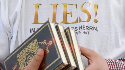 Ein Islamist verteilt am Potsdamer Platz in Berlin kostenlose Koran-Exemplare an Passanten. Die Koran-Verteilung wurde von den radikalislamischen Salafisten initiiert.