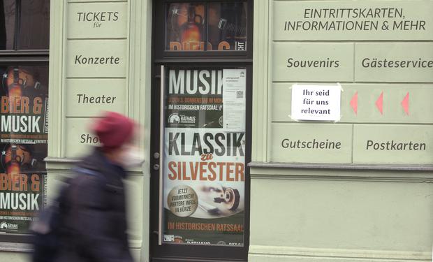 Eine Frau geht in Köpenick an einem geschlossenen Geschäft für Konzertkarten vorbei.