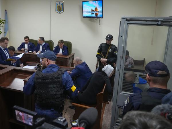Wadim Sch. (rechts, im Glaskäfig) bekennt sich am Mittwoch in Kiew des Mordes schuldig. Vor ihm, im blauen Anzug, sitzt sein ukrainischer Verteidiger Viktor Owsjannikow.