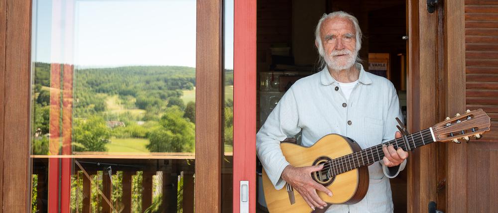 Kinderliedermacher Fredrik Vahle steht mit einer Gitarre in seinem Haus. Er feiert am 24. Juni seinen 80. Geburtstag. 