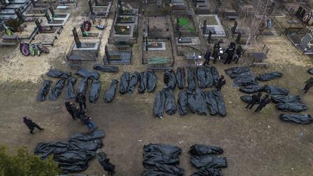 Polizisten arbeiten nach der Tötung von Zivilisten in Butscha an der Identifizierung der Leichen, bevor diese in die Leichenhalle gebracht werden.