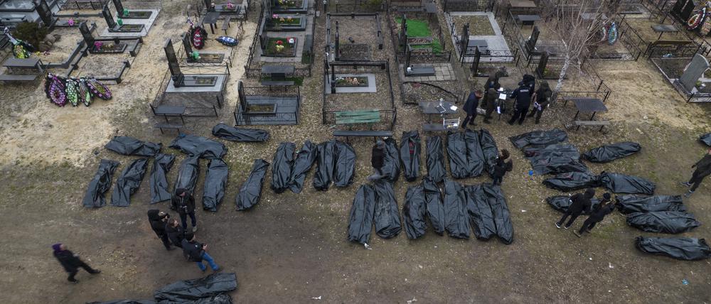 Polizisten arbeiten nach der Tötung von Zivilisten in Butscha an der Identifizierung der Leichen, bevor diese in die Leichenhalle gebracht werden.