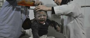 Zwei Ärzte versorgen einen syrischen Jungen, der während des Angriffs der syrischen Luftwaffe in Ost-Ghouta verwundet worden ist.