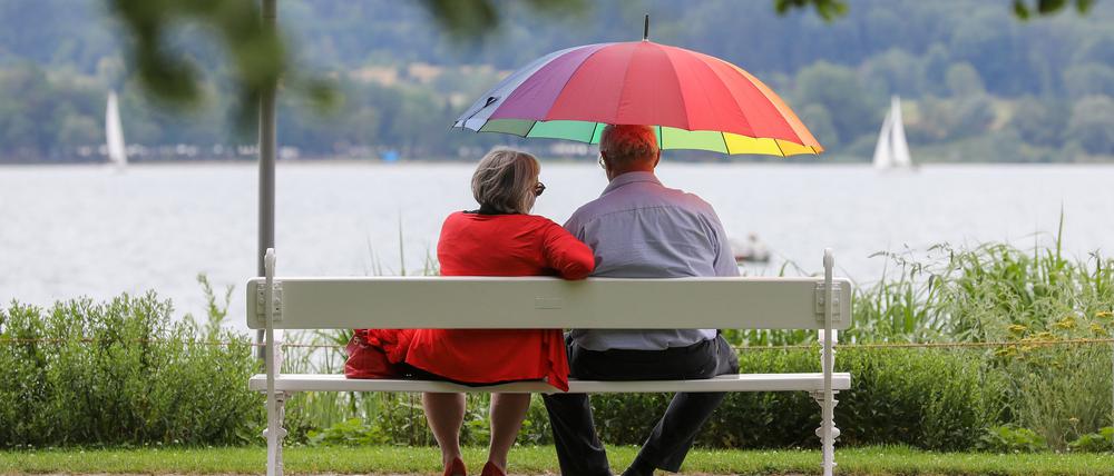 Überlingen: Ein Seniorenpaar sitz auf einer Bank unter einem Schirm.