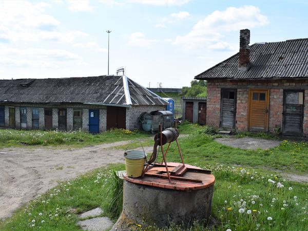 Ein alter Brunnen, leere Schuppen, ein Dixiklo – dahinter beginnt Kaliningrad.