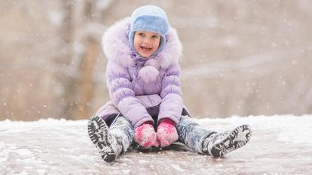 Joyful child slides down the icy hill