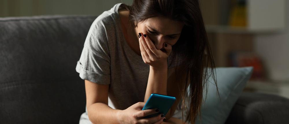 Sad teen receiving bad news online at home.