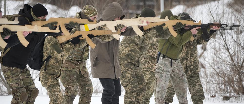 Anwohner trainieren in der Nähe von Kiew mit Holzattrappen als Gewehr.