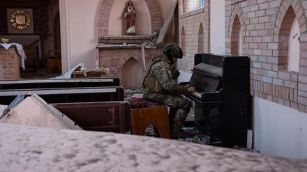 Paradies in der Hölle. Militärseelsorger Mark Kupchenenko spielt in einer zerstörten Kirche Klavier. Das Foto wurde am ersten Weihnachtstag aufgenommen.