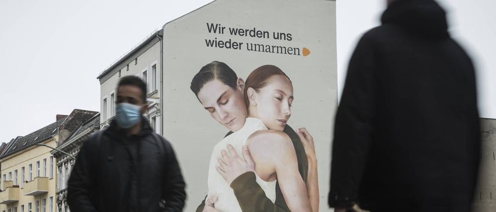 Ein Werbebild mit zwei sich umarmenden Menschen in Berlin-Neukölln. / Foto: bildgehege Wandbild Umarmung *** A mural with two people hugging each other in Berlin Neukölln photo bildgehege mural hug