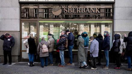 TOPSHOT - People queue outside a branch of Russian state-owned bank Sberbank to withdraw their savings and close their accounts.