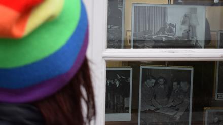 Ulrike Luther blickt durch ein Fenster am Haus der Wannsee-Konferenz auf ein Bild ihres Großvaters als NS-Beamter am Schreibtisch.