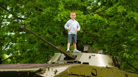 boy child explores old vintage military tank