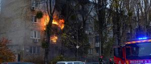 Feuerwehrleute arbeiten daran, ein Feuer in einem Wohnhaus in Kiew zu löschen, das von einem russischen Angriff getroffen wurde. 