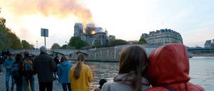 Menschen schauen auf den Brand der Kathedrale Notre-Dame in Paris.