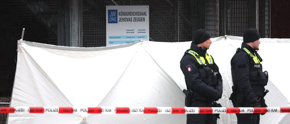 Zwei Polizeibeamte stehen vor dem Versammlungsgebäude der Zeugen Jehovas im Stadtteil Alsterdorf.