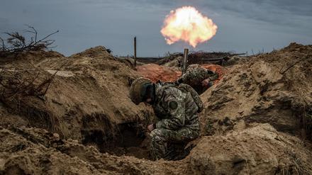 Ukrainische Soldaten feuern aus ihrem Schützengraben.
