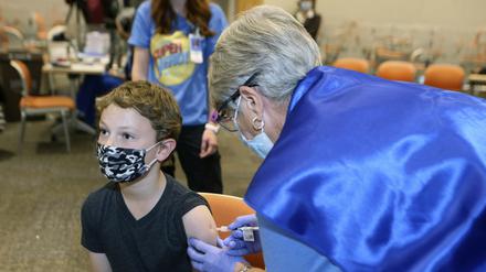 Jackson Stukus (l, 11 Jahre alt) erhält einen Covid-19-Impfstoff von Pfizer in den USA.