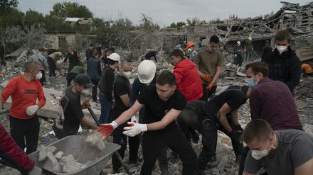 Freiwillige Helfer arbeiten in der Ukraine an der Beseitigung von Trümmern, nachdem mehrere Häuser nach einem Angriff auf ein Wohngebiet zerstört wurden.