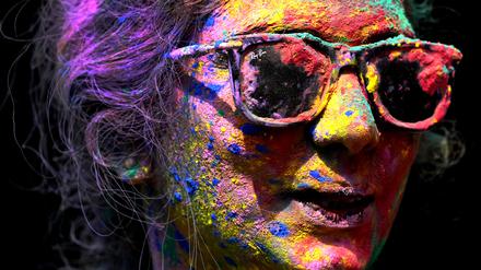 Das Gesicht einer Frau ist mit Farben bemalt, um das Hindu Fest Holi zu feiern. 