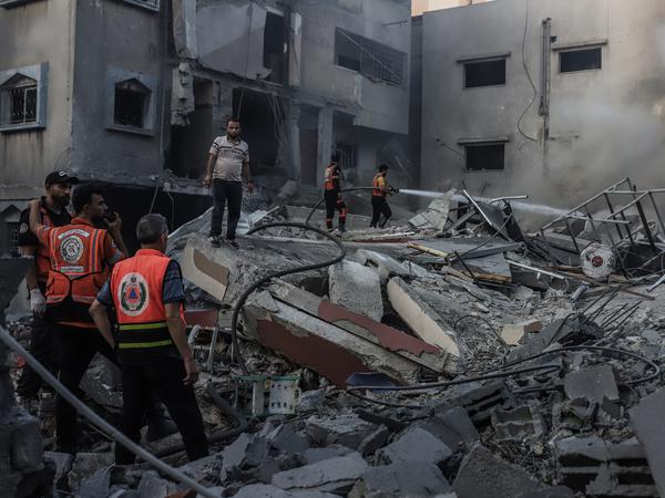 In Gaza-Stadt inspizieren palästinensische Rettungskräfte nach einem israelischen Angriff ein eingestürztes Haus.
