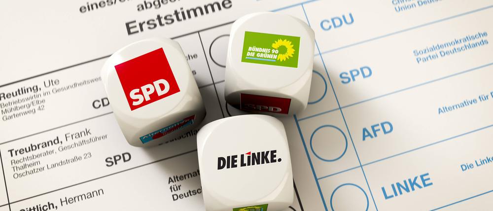 Stimmzettel zur Bundestagswahl, auf dem drei Würfel liegen, der Wurf ergab eine Koalition zwischen SPD, Die Linke und Die Grünen, Rot-Rot-Grün.