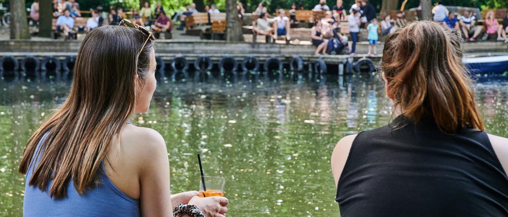 Zwei Frauen sitzen am Wasser im Berliner Cafe am Neuen See. 