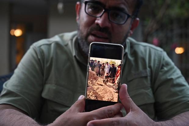 Ein ehemaliger Dolmetscher zeigt ein Foto des Begräbnisses des Lagerarbeiters, der von den Taliban erschossen wurde.