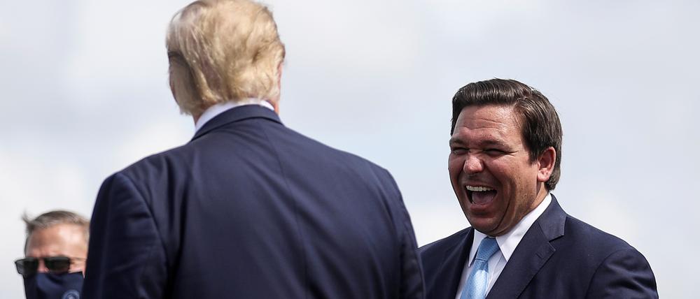 U.S. President Donald Trump is greeted by Florida Governor Ron Desantis as he arrives at Southwest Florida International Airport ahead of a campaign stop in Fort Myers, Florida, U.S., October 16, 2020. REUTERS/Carlos Barria