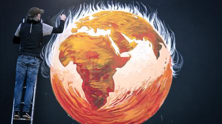 Künstler Greg Mitchell vollendet sein Wandgemälde zum Thema Klimakrise, das die brennende Erde anlässlich UN-Klimakonferenz COP26 in Glasgow zeigt. 