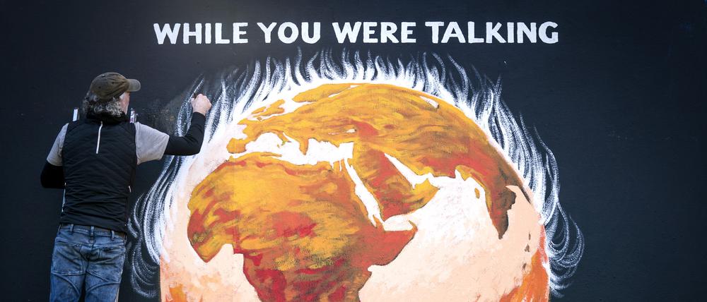 Künstler Greg Mitchell vollendet sein Wandgemälde zum Thema Klimakrise, das die brennende Erde anlässlich UN-Klimakonferenz COP26 in Glasgow zeigt. 
