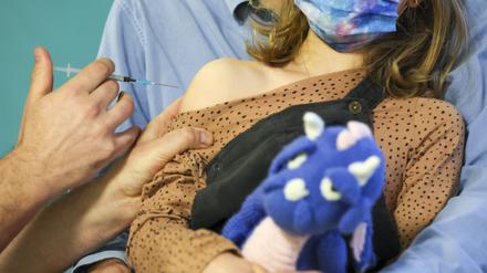 Ein Kinderarzt impft ein 7-jähriges Mädchen gegen das Covid19-Virus. 
