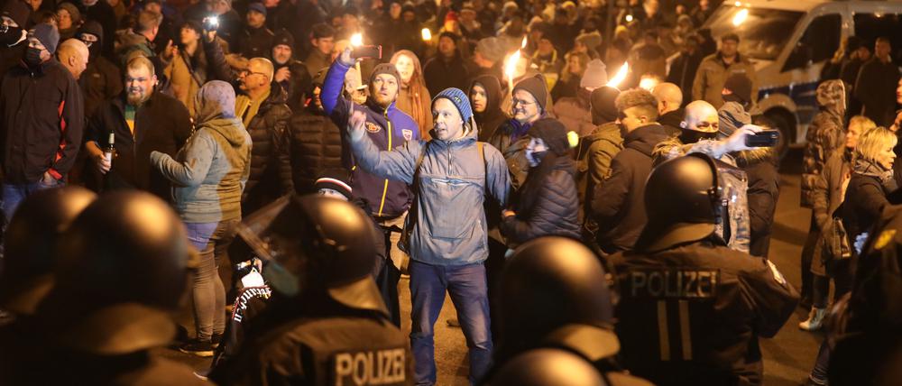 Thüringen, Greiz: Polizisten und Teilnehmer eines so genannten Spaziergangs gegen die Corona-Maßnahmen stehen sich am Abend gegenüber.  