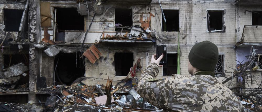 Ein ukrainischer Soldat zeigt in einem Videotelefonat ein durch russische Lufttechnik zerstörtes Haus.