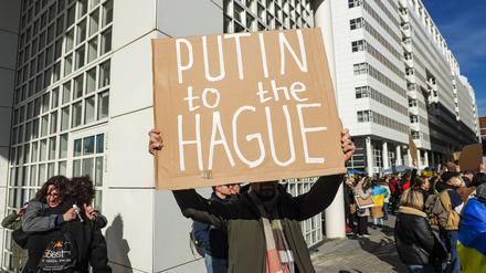 Ein Demonstrant fordert die Überstellung des russischen Präsidenten Wladimir Putins nach Den Haag (englisch: „The Hague“), wo der Internationale Strafgerichtshof sitzt.