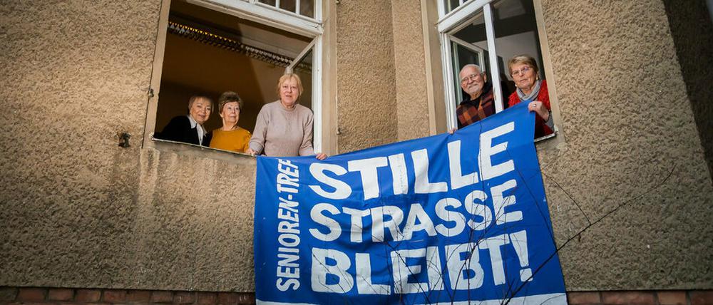 Alle ehemaligen Hausbesetzer:innen, halten am Fenster der «Begegnungsstätte für Jung und Alt» in der Stille Straße 10 in Berlin-Pankow ein altes Protestbanner. 
