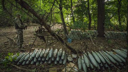Ein ukrainischer Soldat steht neben in den Wäldern nahe der Provinz Saporischschja versteckten Haubitzen-Munition, die für den Beschuss der russischen Stellungen vorbereitet wurden. 