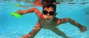 Der sechsjaehrige Rouven taucht am Dienstag (24.06.03) mit seiner Wasserpistole und Chlorbrille im Schwimmbad des suedhessischen Pfungstadt ab und entkommt so der Hitze.Foto: Thomas Lohnes/ddp